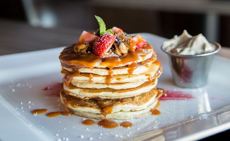 Sweet crepes with strawberries and syrup
